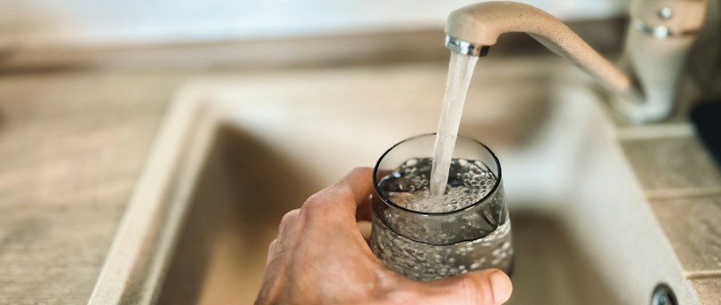Hand holding a glass of tap water