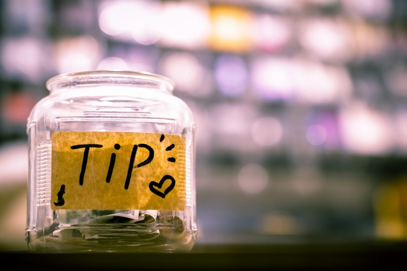 Glass tip jar on a café counter